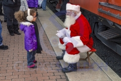 Strasburg, PA - December 19, 2015: A young girl has a word with Santa before posing for pictures at the Strasburg Rail Road.