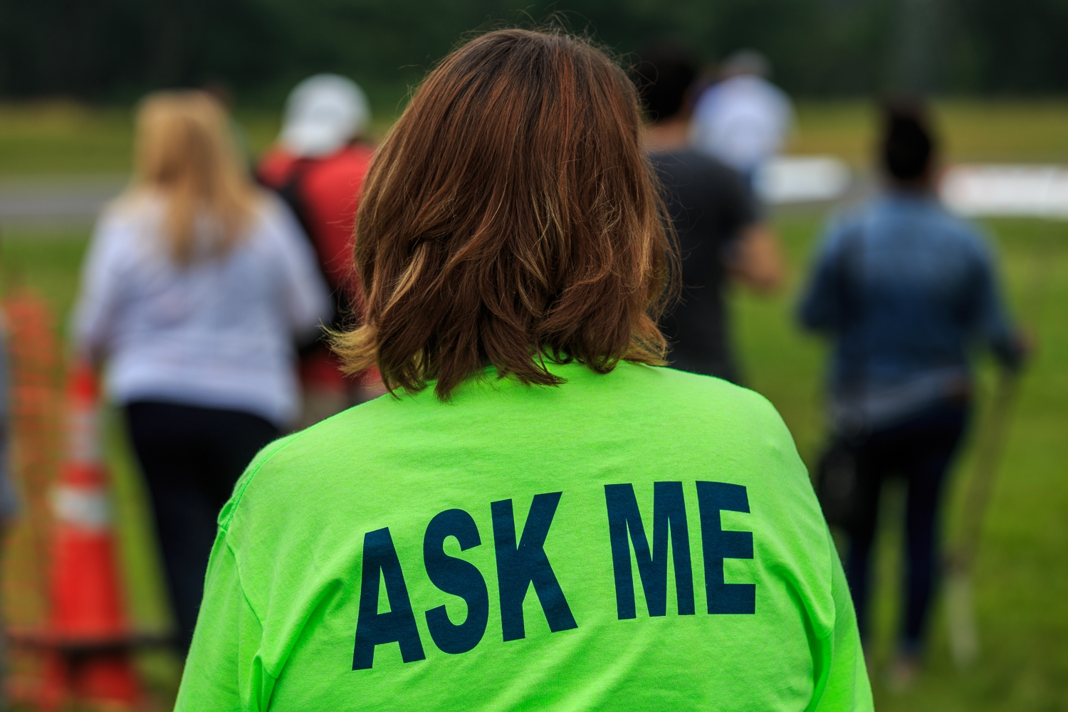 Ask Me - T-shirt-wearing staff helps visitors at a special event.