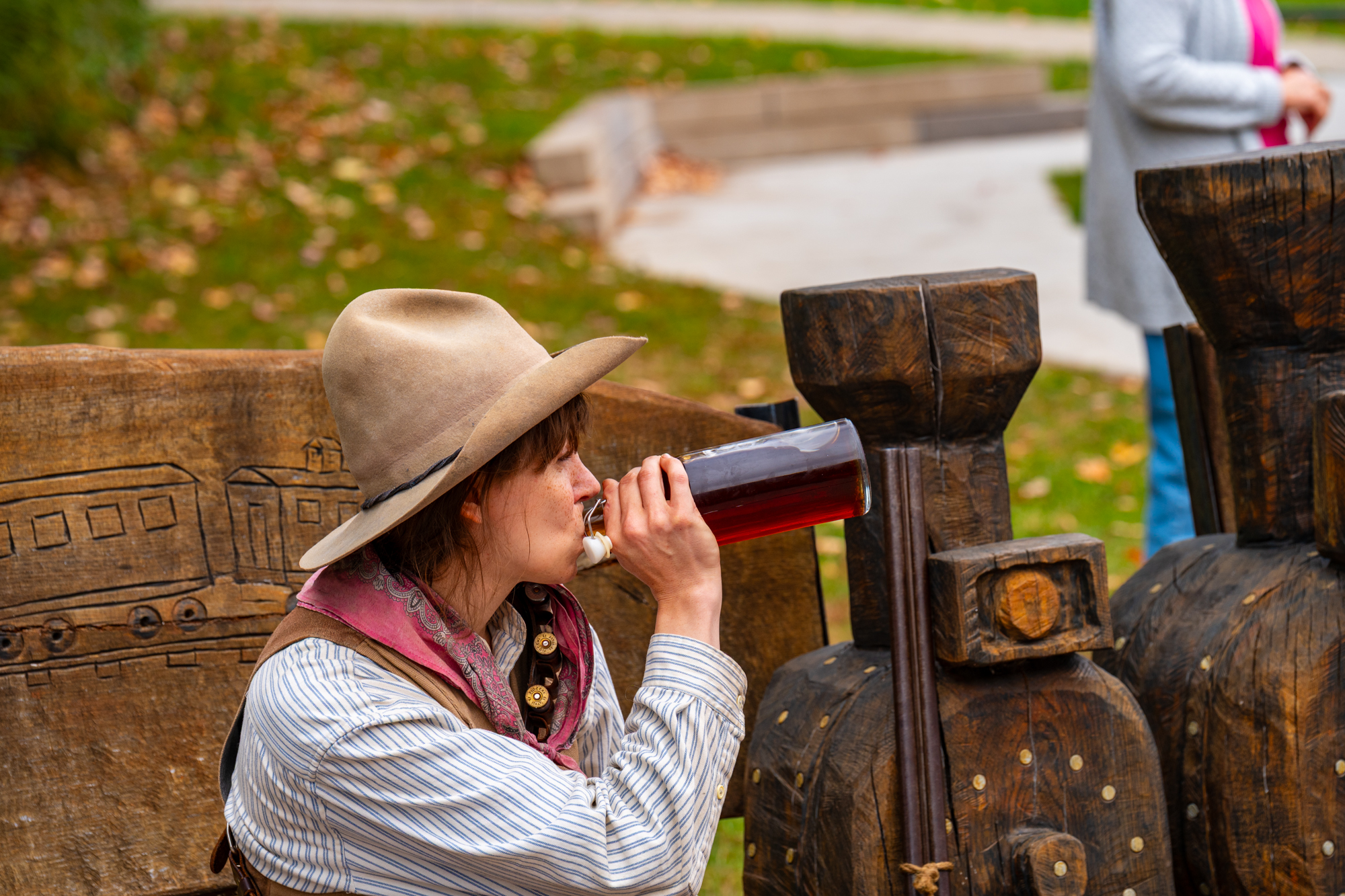 A cowgirl takes enjoys a swig.